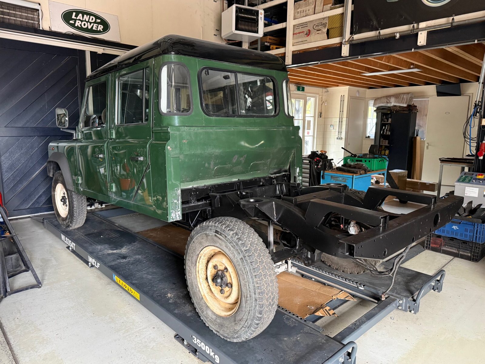 Defender 130 on a workshop lift with chassis exposed